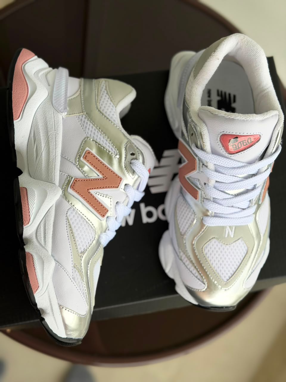 Tenis New Balance blancos con detalles rosa y dorado